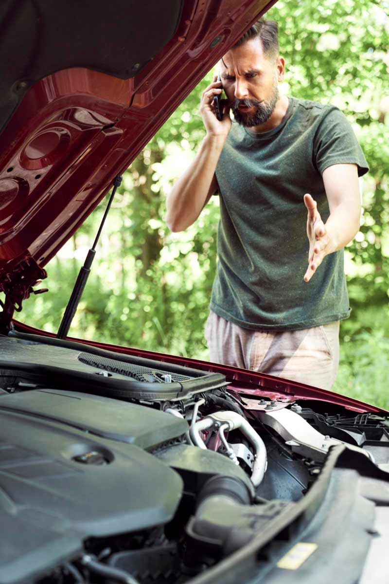 Junger Mann prüft Getriebeschaden bei Schrottauto Ankauf Delmenhorst